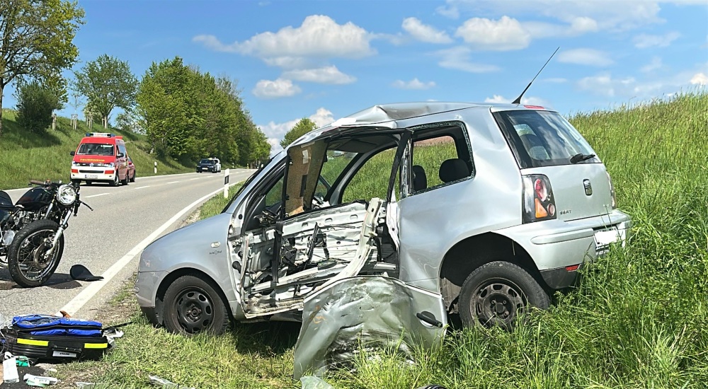 Ein kaputtes Auto und ein kaputtes Motorrad und ein Rettungswagen.