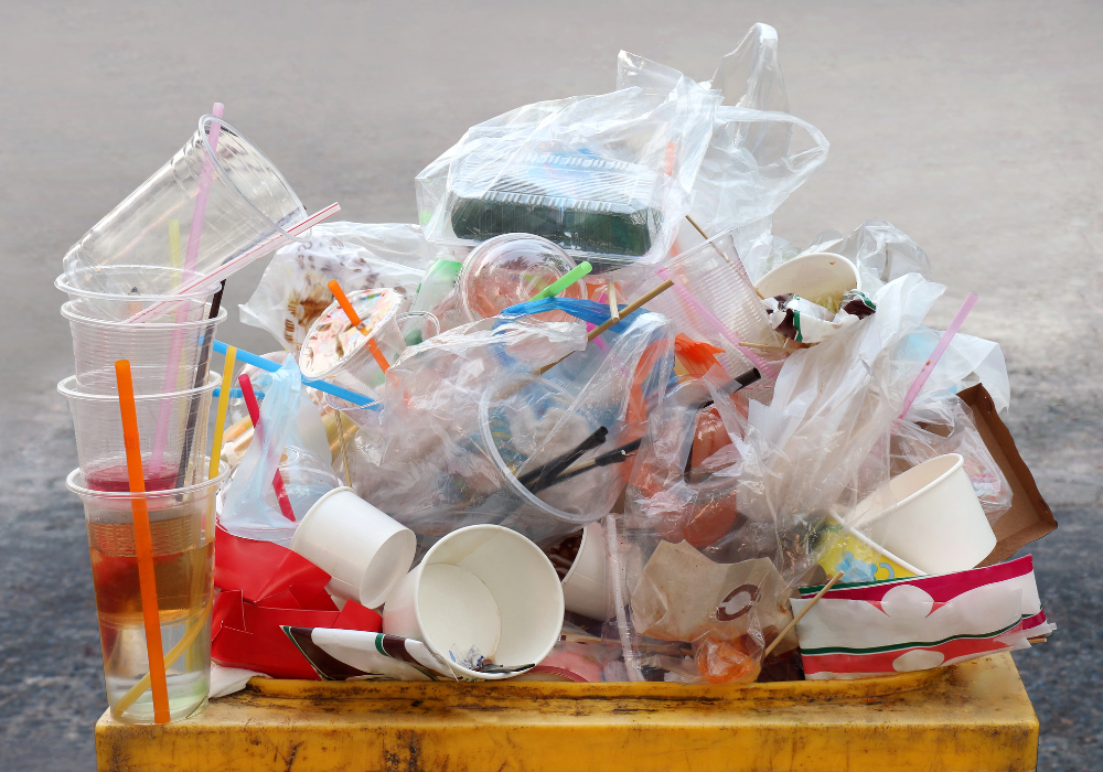 Plastikmüll quillt aus einer Mülltonne