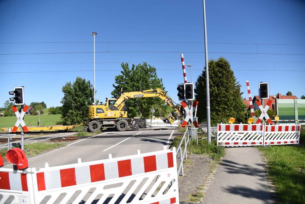 Ein gesperrter Bahnübergang mit einem Bagger.