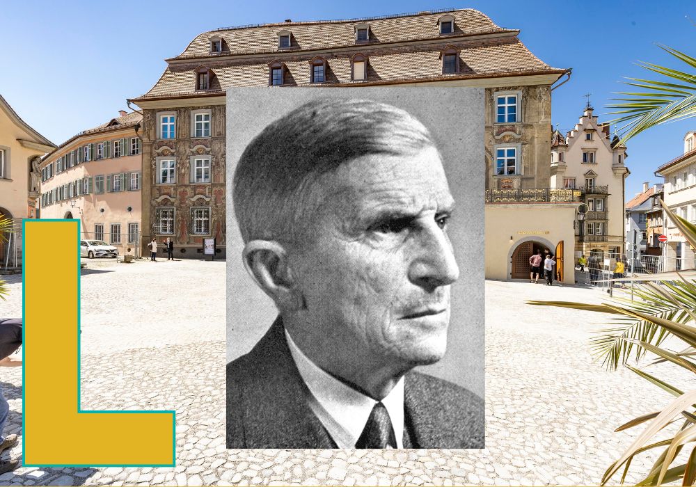Schwarz-Weiß-Portrait vor einem großen Haus mit einem L.