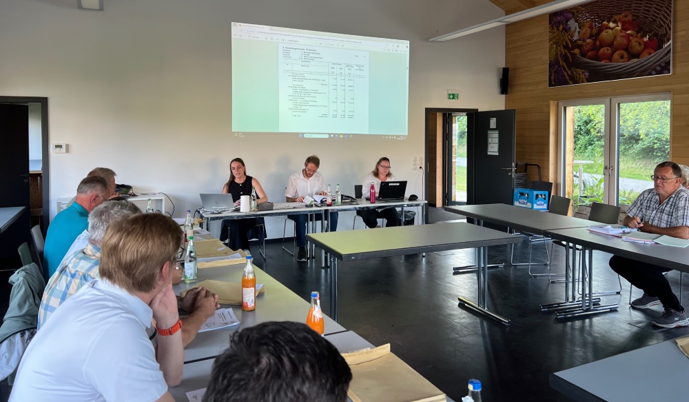 Viele Menschen sitzen in U-Form an einem Tisch