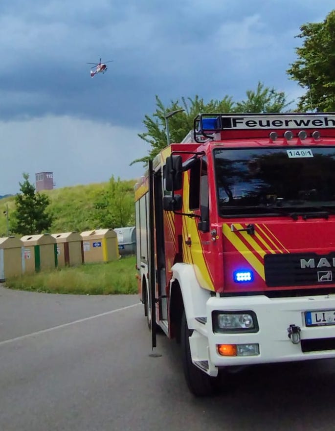 Ein Feuerwehrauto und ein Hubschrauber im Hintergrund.