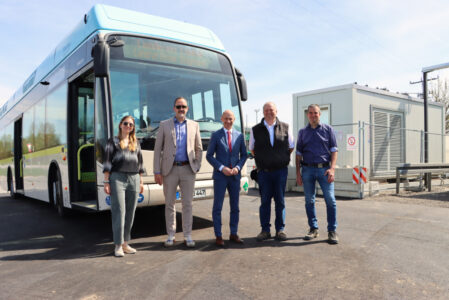 Fünf Menschen stehen vor einem Bus.