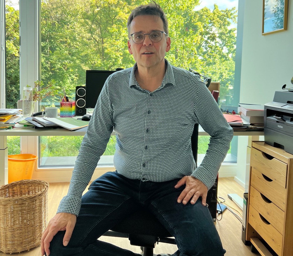 Portrait von einem Mann am Schreibtisch.